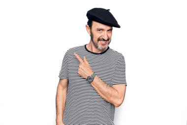 Orta yaşlı, çizgili tişört ve beyaz arka planda Fransız beresi giyen yakışıklı bir adam.