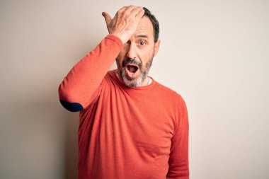 Rastgele turuncu kazak giyen orta yaşlı bir adam izole edilmiş beyaz arka planda dikiliyor. Hatayla el ele tutuşurken şaşırıyor. Hatayı hatırla. Unuttum, kötü hafıza konsepti.