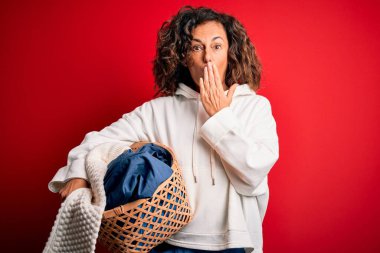 Orta yaşlı, sepet tutan güzel bir kadın. Kırmızı arka planda giysileri var. Ağzı kapalı.