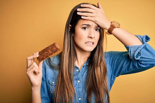 Young Beautiful Girl Holding Healthy Protein Bar Standing Isolated Yellow — Stock Photo, Image