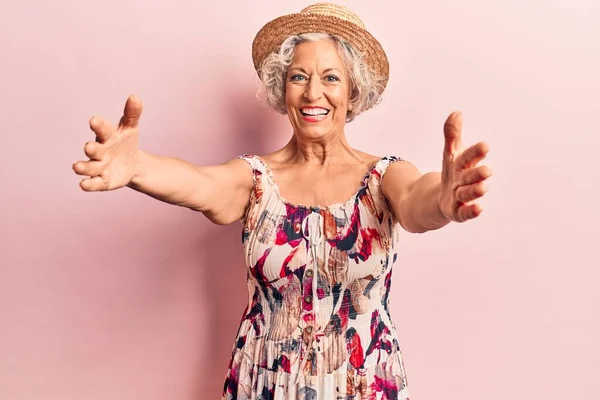 Starsza Siwowłosa Kobieta Letniej Czapce Patrząca Kamerę Uśmiechnięta Otwartymi Ramionami — Zdjęcie stockowe