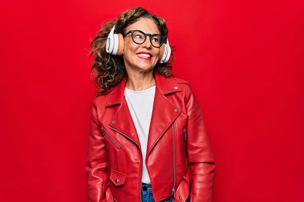 Medelåldern Vacker Kvinna Lyssnar Musik Med Hörlurar Över Röd Bakgrund — Stockfoto