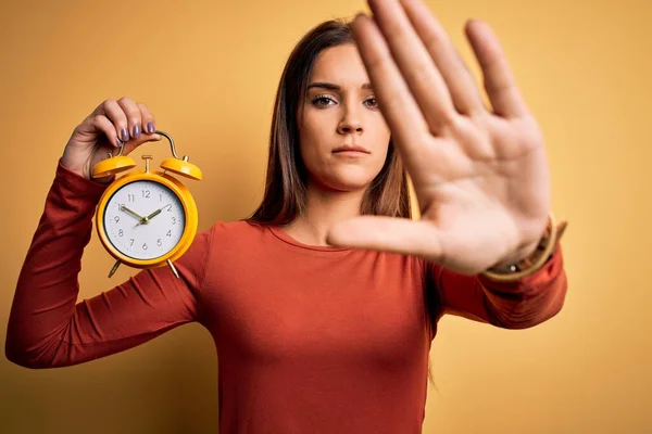 Jeune Belle Femme Brune Tenant Réveil Sur Fond Jaune Isolé — Photo