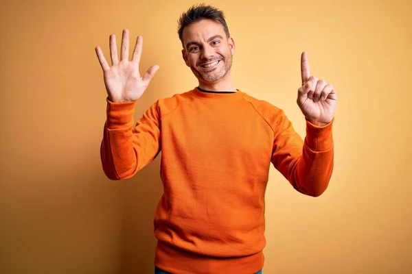 Joven Hombre Guapo Usando Suéter Casual Naranja Pie Sobre Fondo — Foto de Stock