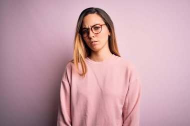 Mavi gözlü, pembe arka planda gözlük takan, kuşkucu ve gergin, sorun yüzünden surat asan güzel sarışın kadın. Negatif kişi.