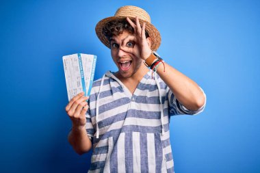 Kıvırcık saçlı, yaz şapkası takan, mutlu yüzüyle biniş kartı tutan, el pençe divan duran genç, sarışın turist.