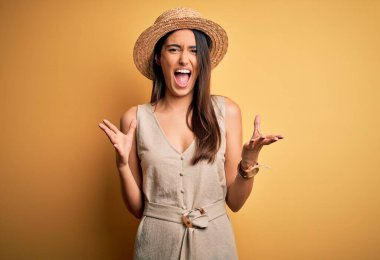 Genç, güzel, esmer kadın tatilde. Sıradan bir elbise giyiyor ve şapkası var. Deli gibi bağırıyor, bağırıyor, agresif bir ifade ve kollar havada. Hayal kırıklığı konsepti.