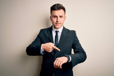 Zarif takım elbiseli ve kravatlı genç yakışıklı iş adamı. Aceleyle saati, sabırsızlığı, gecikmeyi izlemek için acele ediyor.