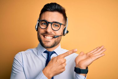 Çağrı merkezinden gelen müşteri hizmetleri kulaklığı takan genç bir işletmeci kameraya hayret ediyor ve gülümsüyor..