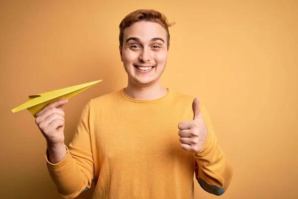 Jonge Knappe Roodharige Man Met Papieren Vliegtuig Geïsoleerde Gele Achtergrond — Stockfoto