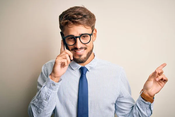 白い背景の上でスマートフォンで会話をしている若いビジネスマンは 手と指を横に向けて非常に幸せなポイント — ストック写真