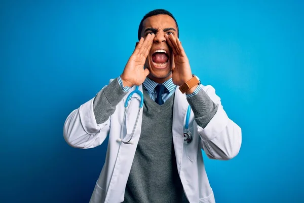 Przystojny Afrykański Lekarz Płaszczu Stetoskopie Niebieskim Tle Krzyczący Wściekły Rękami — Zdjęcie stockowe