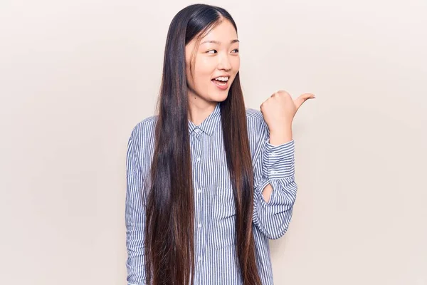 Ung Vacker Kinesisk Kvinna Bär Casual Randig Skjorta Pekar Tummen — Stockfoto