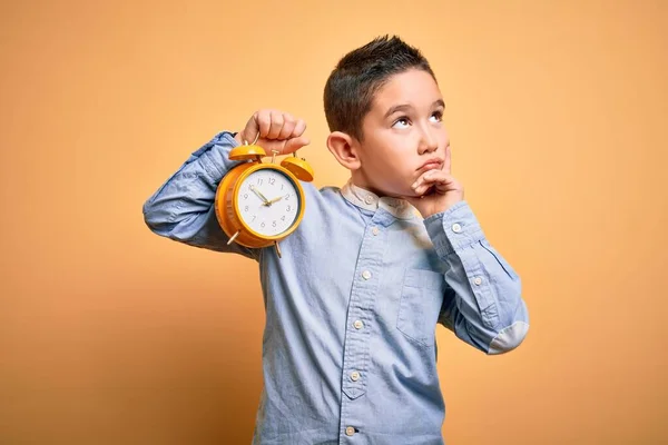 Menino Menino Segurando Clássico Sino Despertador Sobre Isolado Amarelo Fundo — Fotografia de Stock