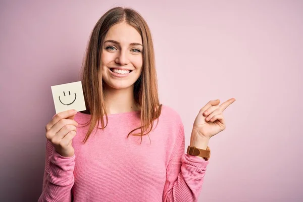 Joven Hermosa Pelirroja Sosteniendo Papel Recordatorio Con Sonrisa Mensaje Emoji —  Fotos de Stock