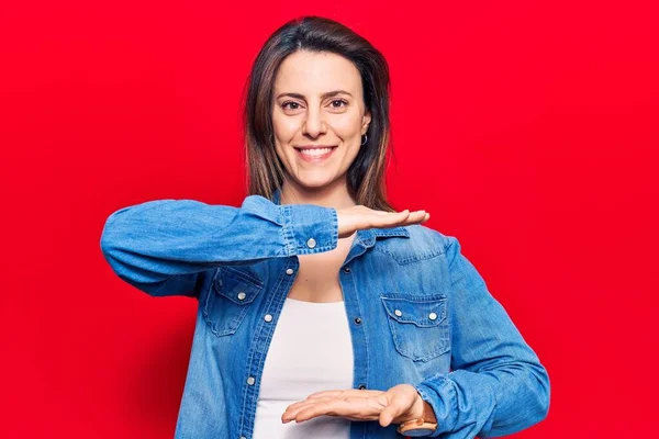 Young beautiful woman wearing casual clothes gesturing with hands showing big and large size sign, measure symbol. smiling looking at the camera. measuring concept.