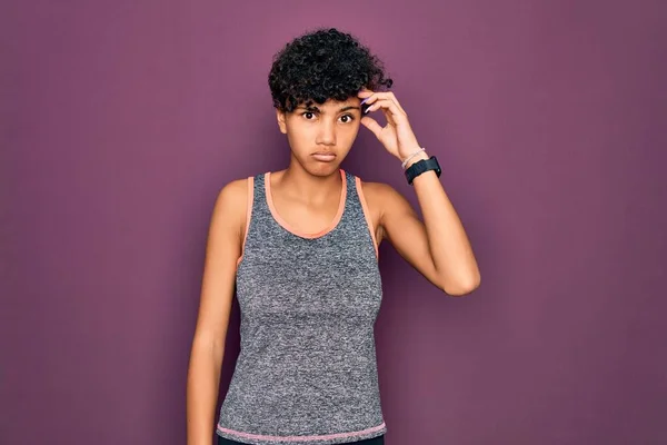 Young beautiful african american afro sportswoman doing exercise wearing sportswear worried and stressed about a problem with hand on forehead, nervous and anxious for crisis