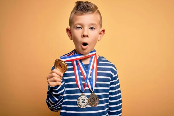 Küçük Beyaz Çocuk Sarı Arka Planda Ödül Yarışması Madalyası Takıyor — Stok fotoğraf