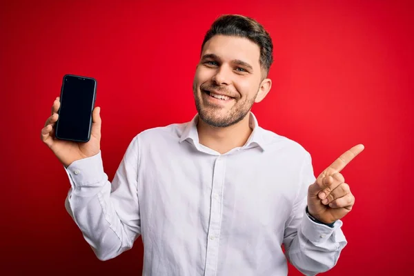 Junger Geschäftsmann Mit Blauen Augen Zeigt Smartphone Bildschirm Auf Rotem — Stockfoto