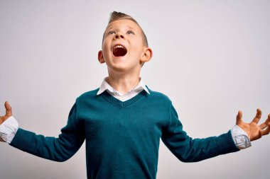 Mavi gözlü küçük beyaz bir çocuk soyutlanmış arka planda şık giysiler giymiş çılgın ve sinirli bir şekilde bağırıyor ve agresif bir ifade ve kolla bağırıyor. Hayal kırıklığı konsepti.