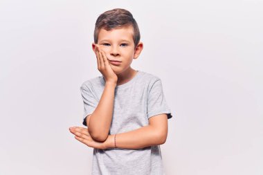 Hoş sarışın çocuk gündelik kıyafetler giyip kollarını kavuşturarak depresyondan sıkılmış ve yorgun görünüyor.. 