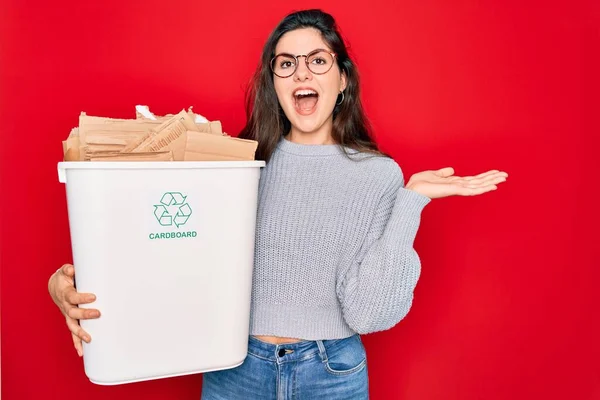 エコ環境のためのリサイクル段ボール容器リサイクルを保持する若い美しい女性は非常に満足し 興奮し 大きな笑顔と上げ手で叫んで勝利を祝う表現 — ストック写真