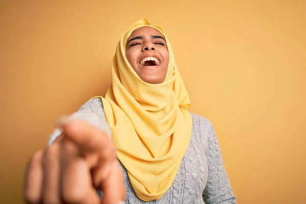 若いです美しいですアフリカ系アメリカ人の女の子身に着けていますイスラム教徒のヒジャーブ上に隔離された黄色の背景笑いますあなたで 手でカメラに指を指して体 恥表現 — ストック写真
