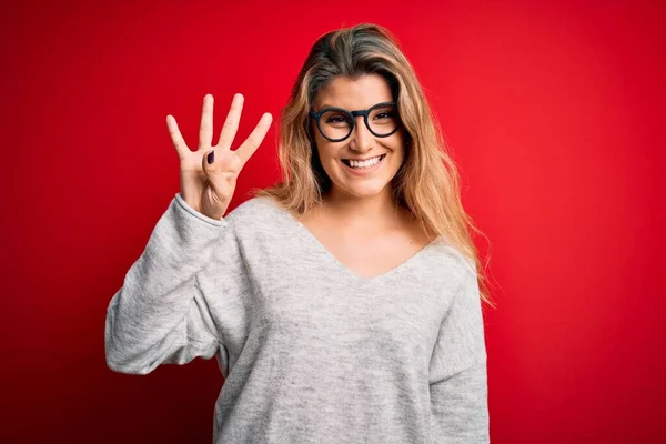 Jovem Mulher Loira Bonita Vestindo Suéter Óculos Sobre Fundo Vermelho — Fotografia de Stock