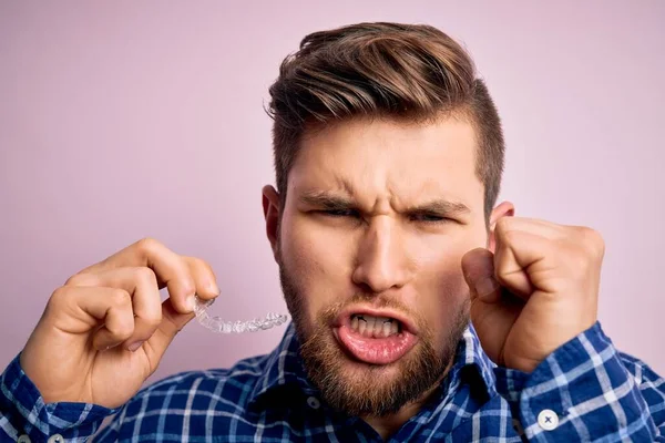 Jonge Blonde Man Met Baard Blauwe Ogen Houden Tandheelkundige Uitlijning — Stockfoto