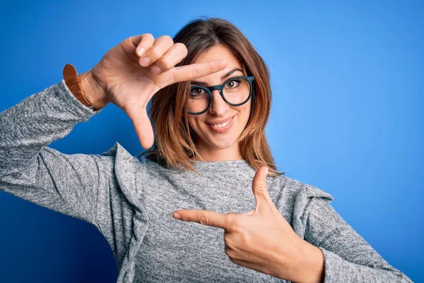 Młoda Piękna Brunetka Ubrana Luźny Sweter Okulary Niebieskim Tle Uśmiechnięta — Zdjęcie stockowe