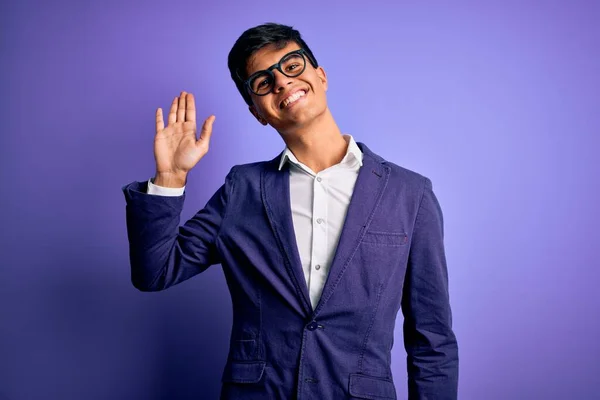 Mladý Pohledný Obchodník Bundě Brýlích Izolovaném Purpurovém Pozadí Vzdává Pozdravu — Stock fotografie
