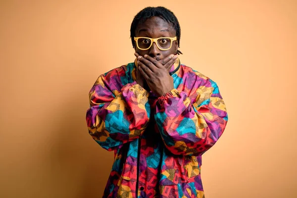 Красивый Африканский Американец Разноцветном Пальто Очках Жёлтом Фоне Шокировал Закрывая — стоковое фото
