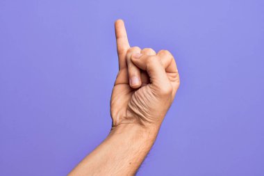 İzole edilmiş mor arka planda parmaklarını gösteren beyaz bir gencin eli serçe parmağının söz verme sözü olduğunu gösteriyor. Bir numara: