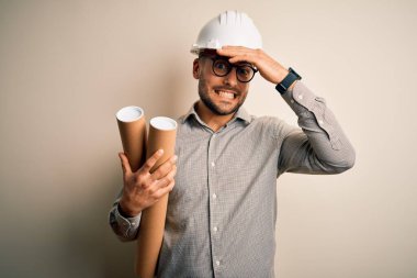 Müteahhit miğferi takan genç bir mimar, proje kâğıt planını izole edilmiş arka planda tutarken el ele, utanç ve şaşkınlık dolu yüzlerle, sinirli ve hayal kırıklığına uğramış bir şekilde vurguladı. Hata için korku ve üzüntü.