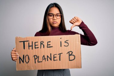 Genç Asyalı aktivist kız, gezegen mesajlı pankart istiyor. Sinirli surat, olumsuz işaret baş parmakları aşağıda, reddedilme konsepti yok.