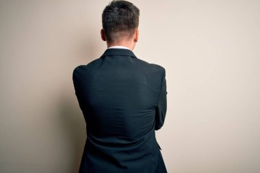 Zarif takım elbiseli ve kravatlı genç yakışıklı iş adamı soyutlanmış arka planda kendine mutlu ve olumlu bir şekilde sarılıyor. Sevgi ve özgüven.