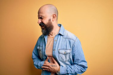 Sakallı, sıradan bir kot ceket giyen, eli göbeğinde çizgili tişört giyen yakışıklı kel bir adam. Çünkü mide bulantısı, acı verici bir hastalık. Ache kavramı.