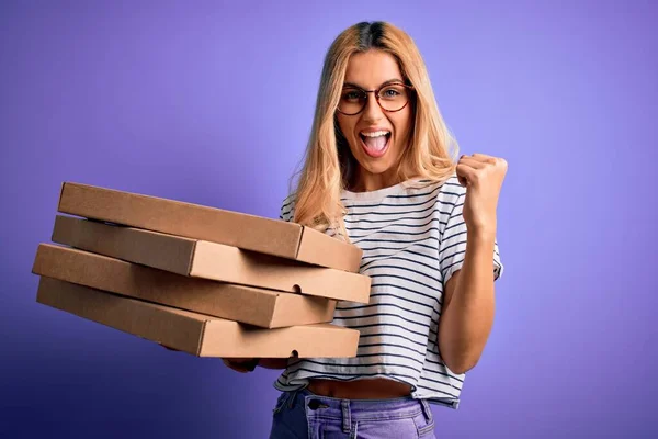 若いです美しいですブロンド女性保持ボックスのイタリアのピザ上の隔離された紫色の背景悲鳴誇りと勝利と成功を祝う非常に興奮 応援感情 — ストック写真