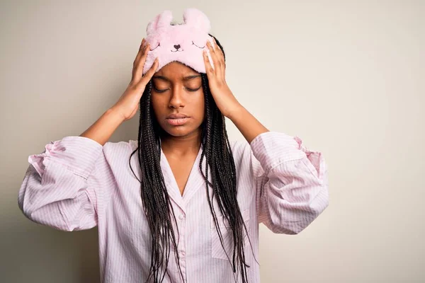 年轻的非洲裔美国女人 头戴粉色睡衣 戴着睡眠面罩 背对着孤立的背景 头戴痛苦 因为压力 痛苦的偏头痛 — 图库照片
