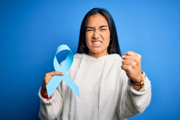 Młoda Azjatycka Kobieta Trzyma Niebieski Symbol Wstążki Raka Stojąc Odosobnionym — Zdjęcie stockowe