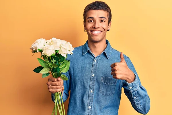 Ung Afrikansk Amercian Man Som Håller Blommor Ler Glad Och — Stockfoto