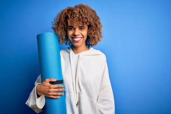 Junge Afrikanisch Amerikanische Sportlerin Hält Yogamatte Über Isoliertem Blauem Hintergrund — Stockfoto