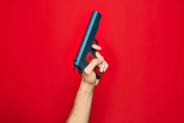 Krásná Ruka Muže Drží Zbraň Přes Izolované Červené Pozadí — Stock fotografie