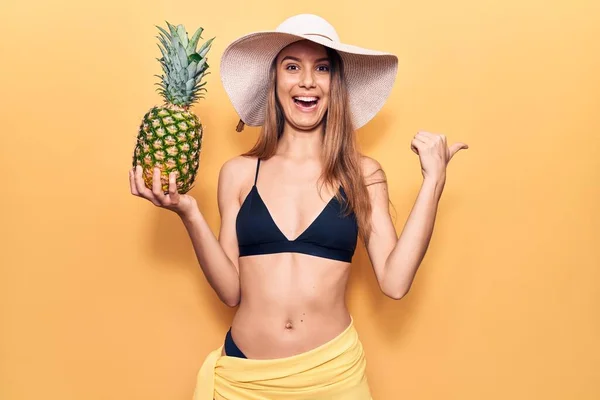 Ung Vacker Flicka Bikini Och Hatt Håller Ananas Pekar Tummen — Stockfoto