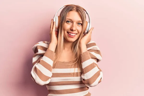 Νεαρή Ξανθιά Γυναίκα Που Ακούει Μουσική Ακουστικά Που Φαίνονται Θετικά — Φωτογραφία Αρχείου