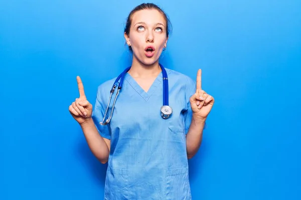 Jovem Loira Vestindo Uniforme Médico Estetoscópio Surpreso Surpreso Olhando Para — Fotografia de Stock