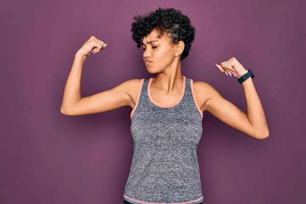 年轻美丽的非洲裔美国女运动员穿着运动服做运动 露出胳膊肌肉 带着自豪的笑容 健康概念 — 图库照片
