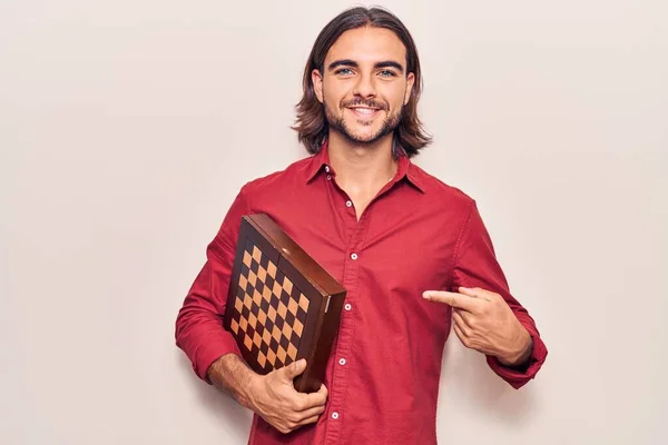 Jovem Homem Bonito Segurando Xadrez Sorrindo Feliz Apontando Com Mão — Fotografia de Stock