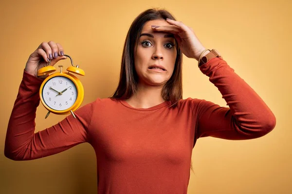 Jonge Mooie Brunette Vrouw Met Wekker Geïsoleerde Gele Achtergrond Gestrest — Stockfoto