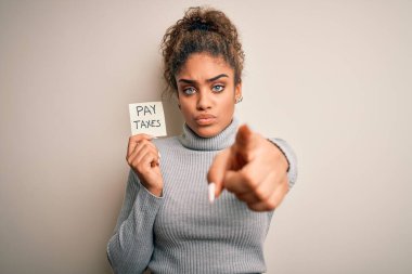 Afro-Amerikan Afrikalı genç kız elinde hatırlatma kağıdı tutuyor. Ödeme vergileriyle kamerayı işaret ediyor. Ve sen, el işareti, ön taraftan pozitif ve kendinden emin bir hareket.